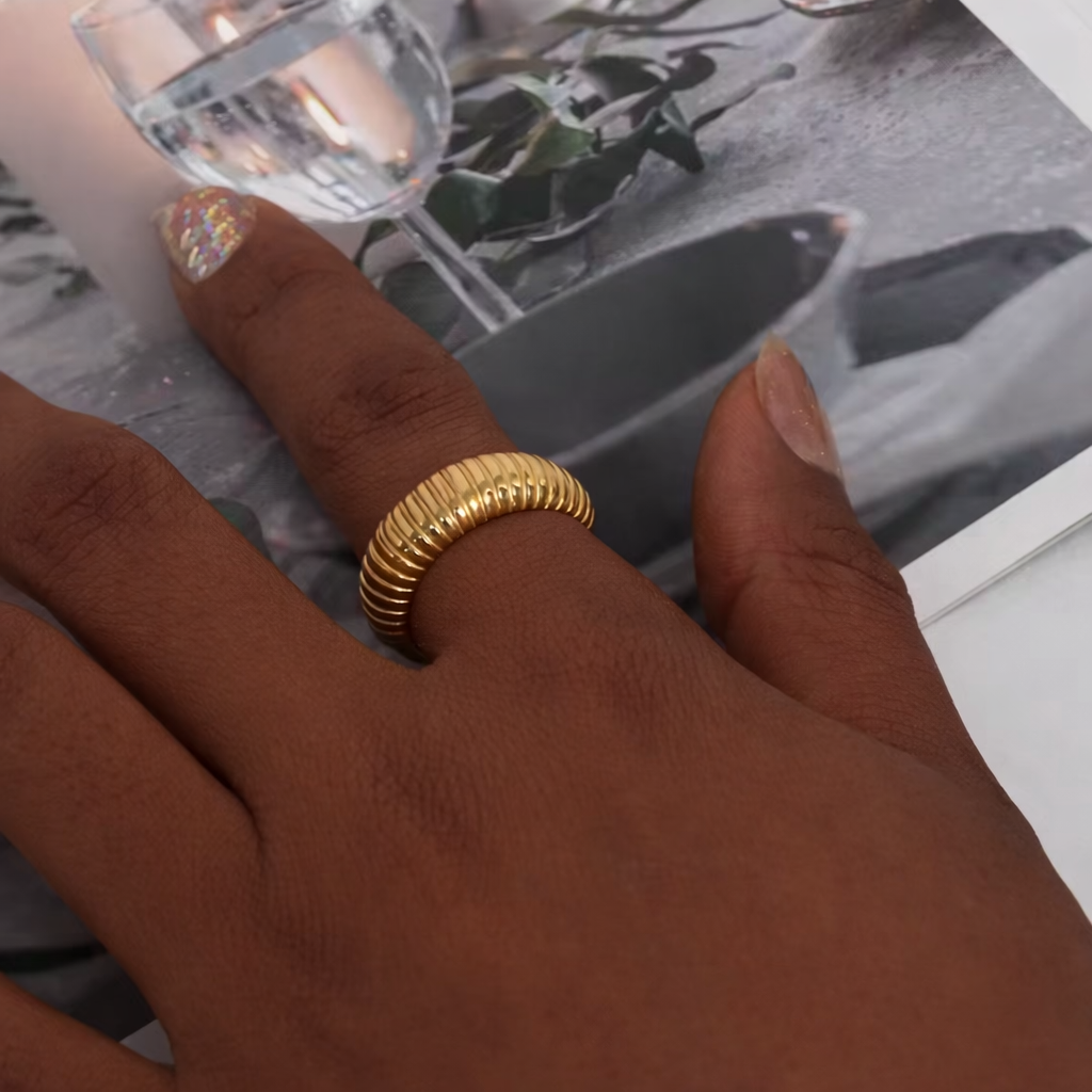 Gold ring on a person's finger with a blurred background